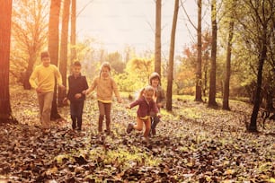 Grande grupo de crianças correndo no parque. Outono.
