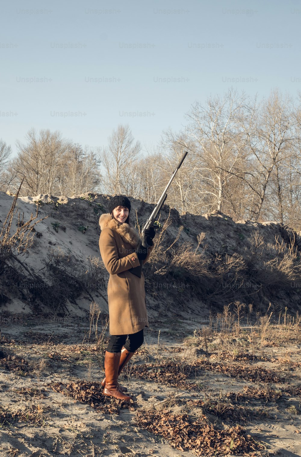 English hunting. Young beautiful woman in a hunting coat with a gun in his hand. Traditional hunting in Britain