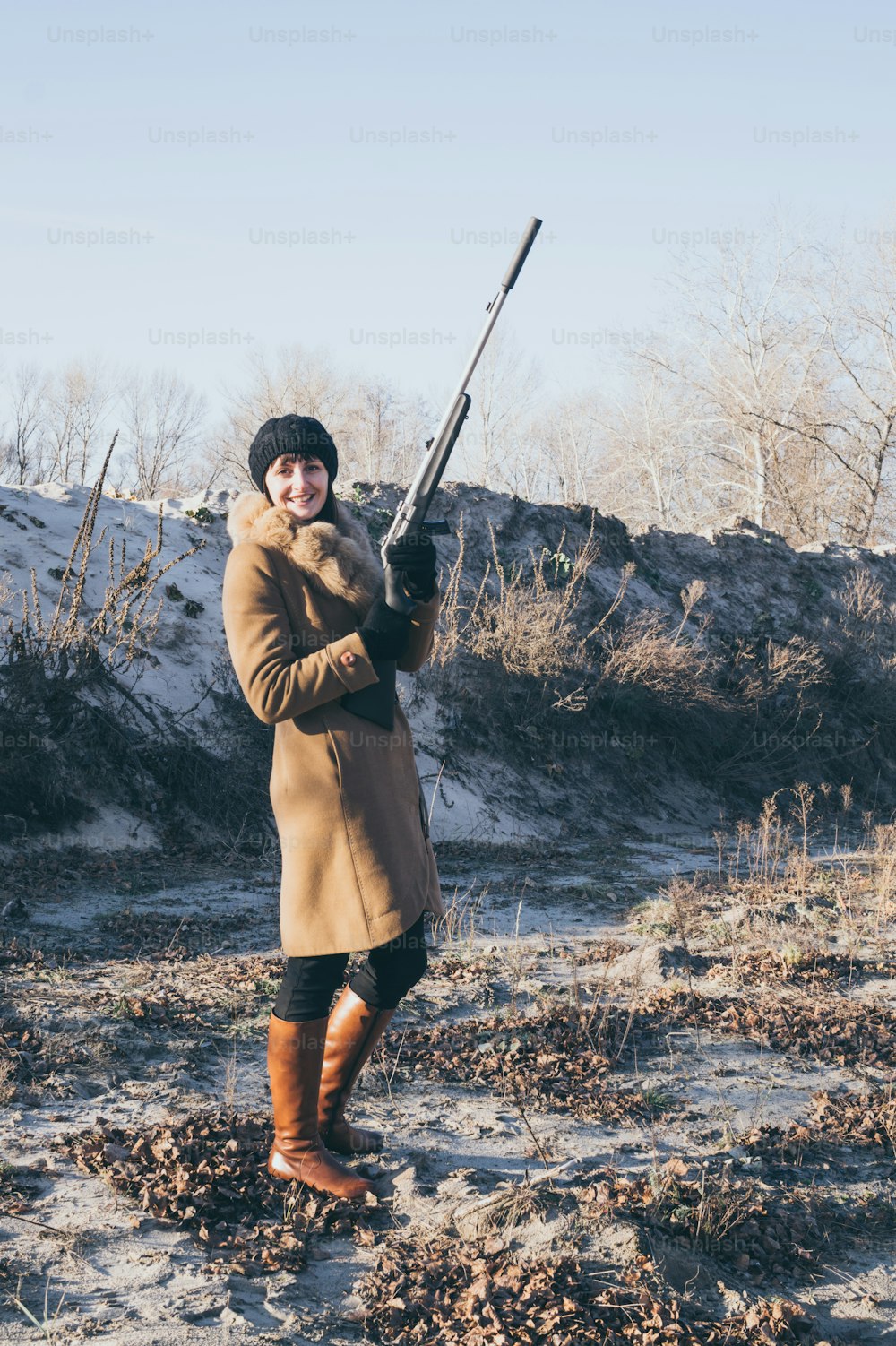 Caza inglesa. Joven hermosa mujer con un abrigo de caza con una pistola en la mano. Caza tradicional en Gran Bretaña