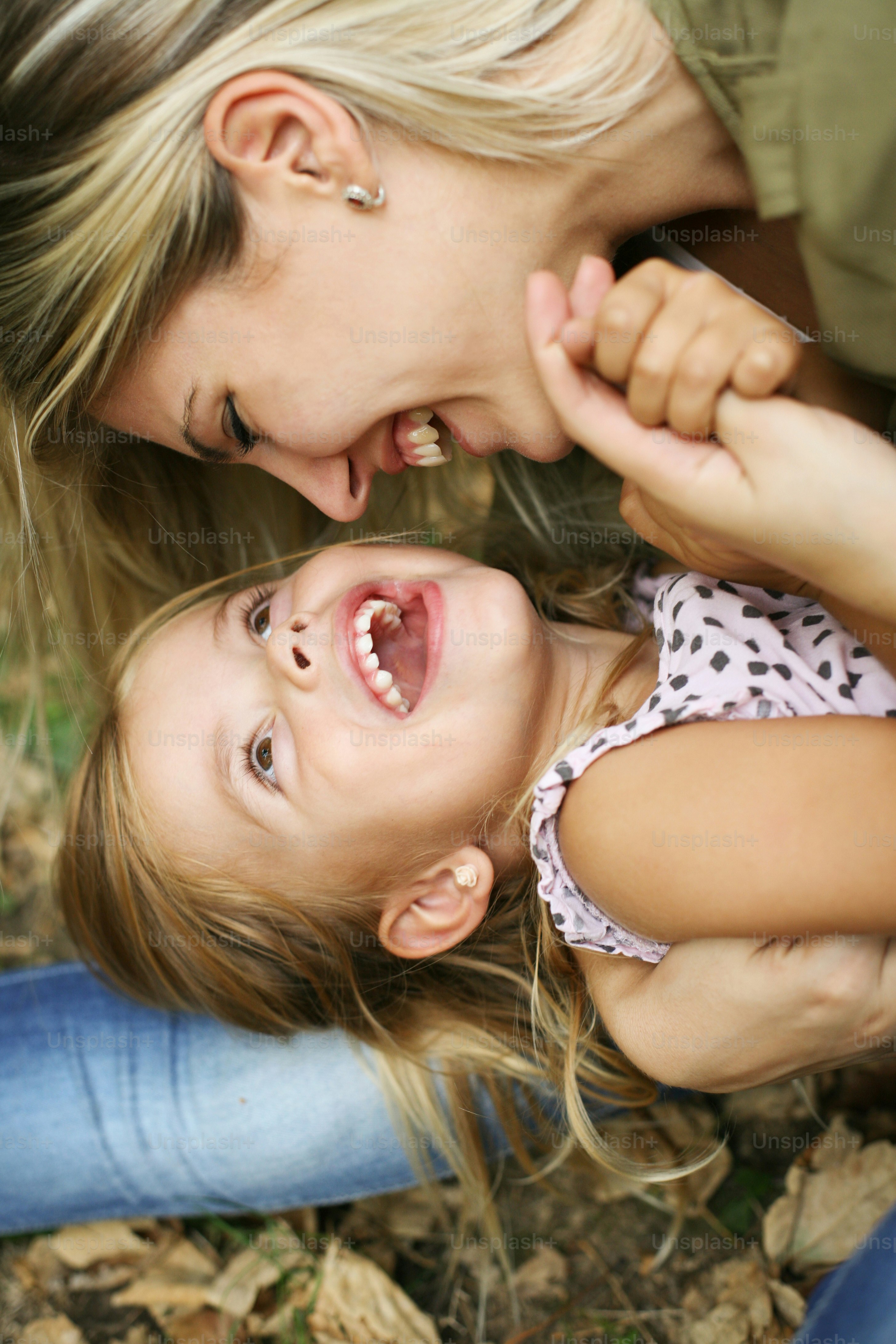 Little girl wit her mother in the park.Little girl lying on mother lap.