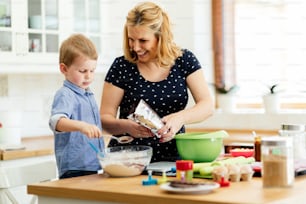 Mother and child preparing cookies in kitchen