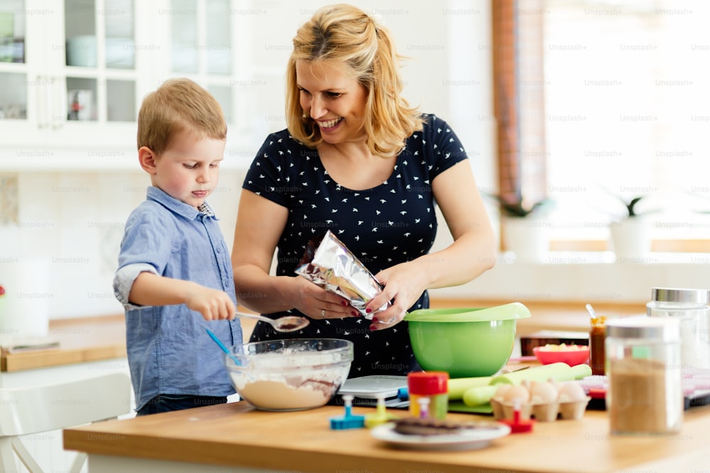 Mãe e filho preparando biscoitos na cozinha