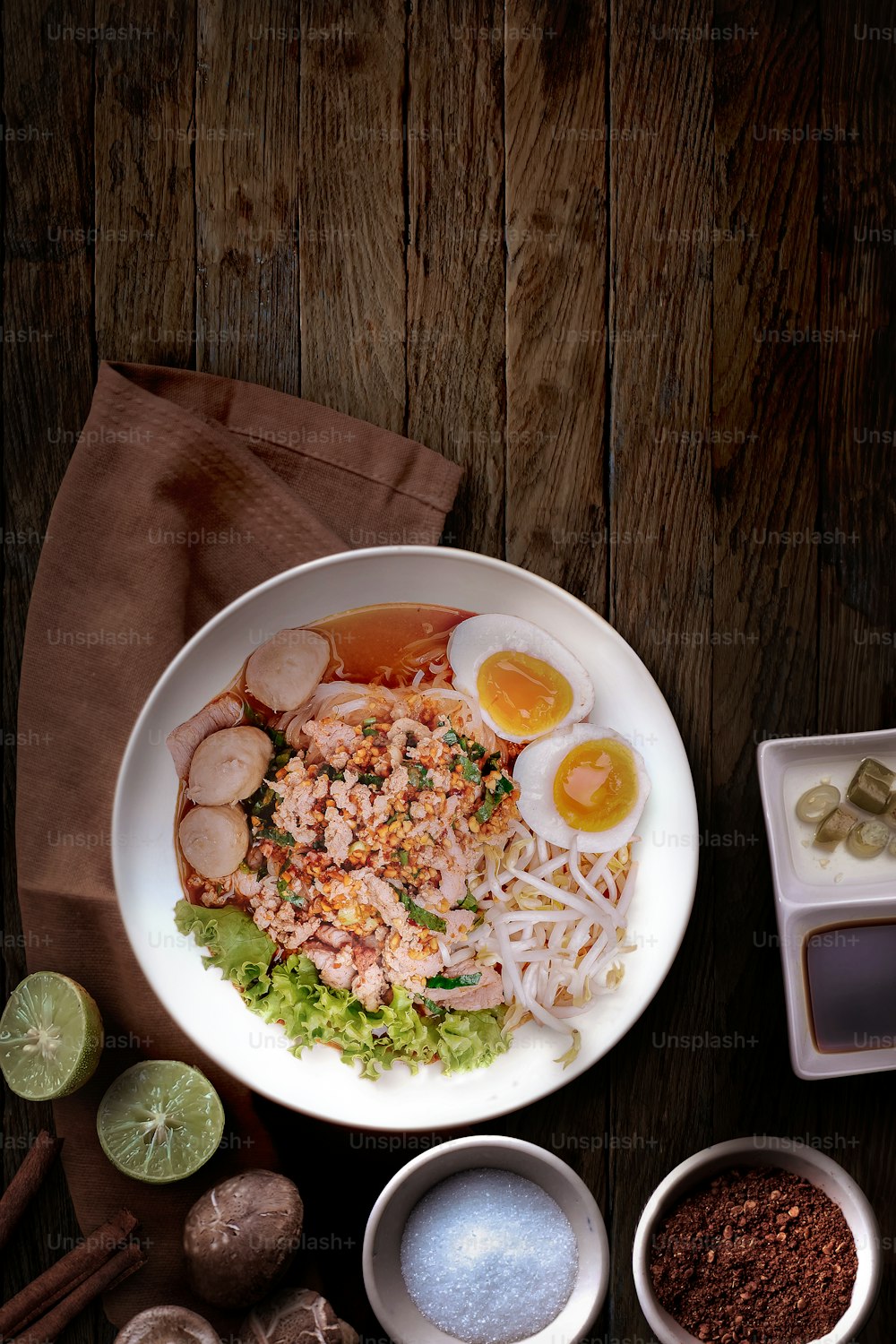Fideos Tom Yum con cerdo asado y huevo sobre mesa de madera. Cocina tailandesa
