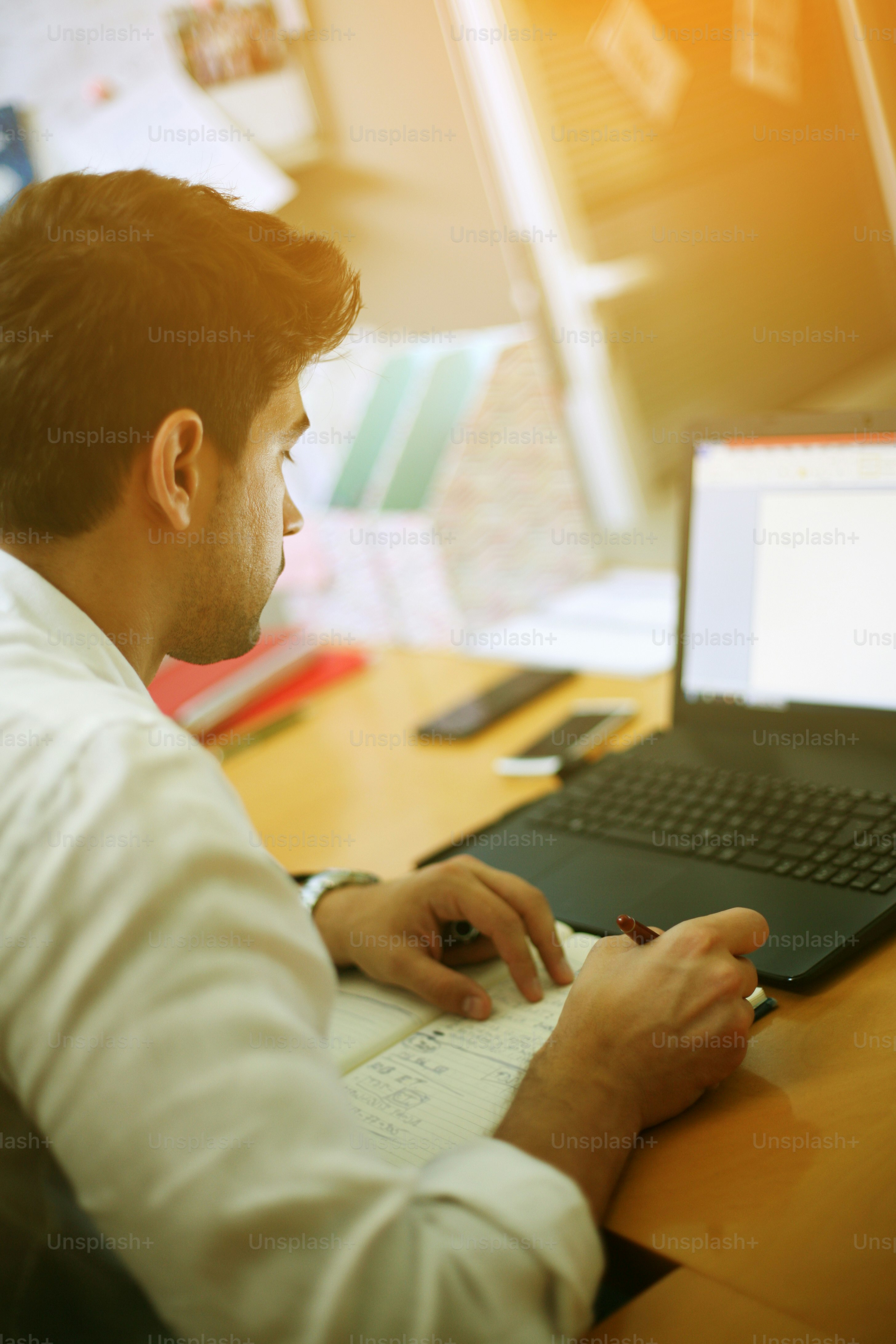 Young entrepreneur taking notes in the office. photo – Public housing ...