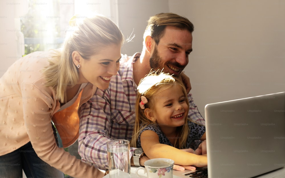 Little girl spending time with her father and mother at home.