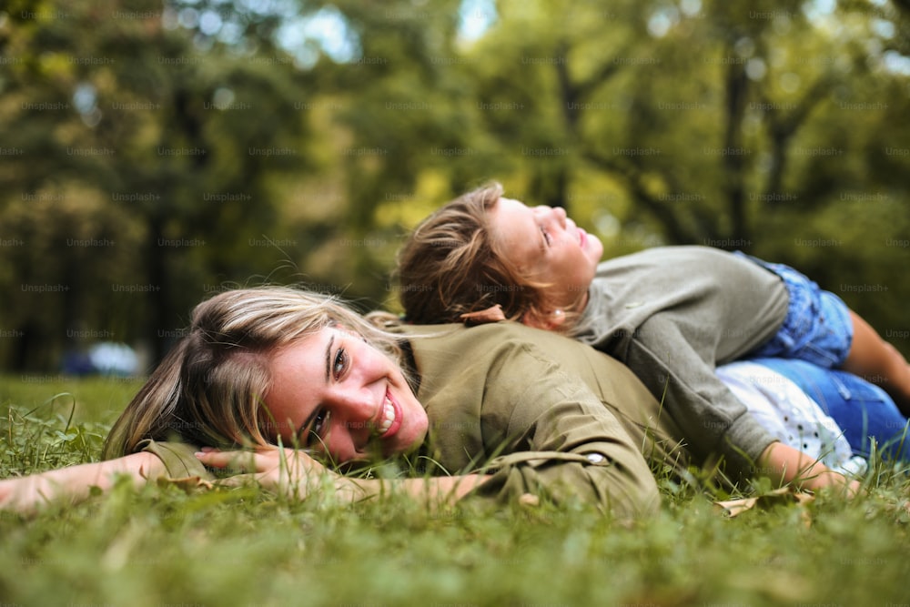 어머니 등에 누워 있는 어린 소녀. 풀밭에 누워 있는 딸과 함께 있는 어머니.
