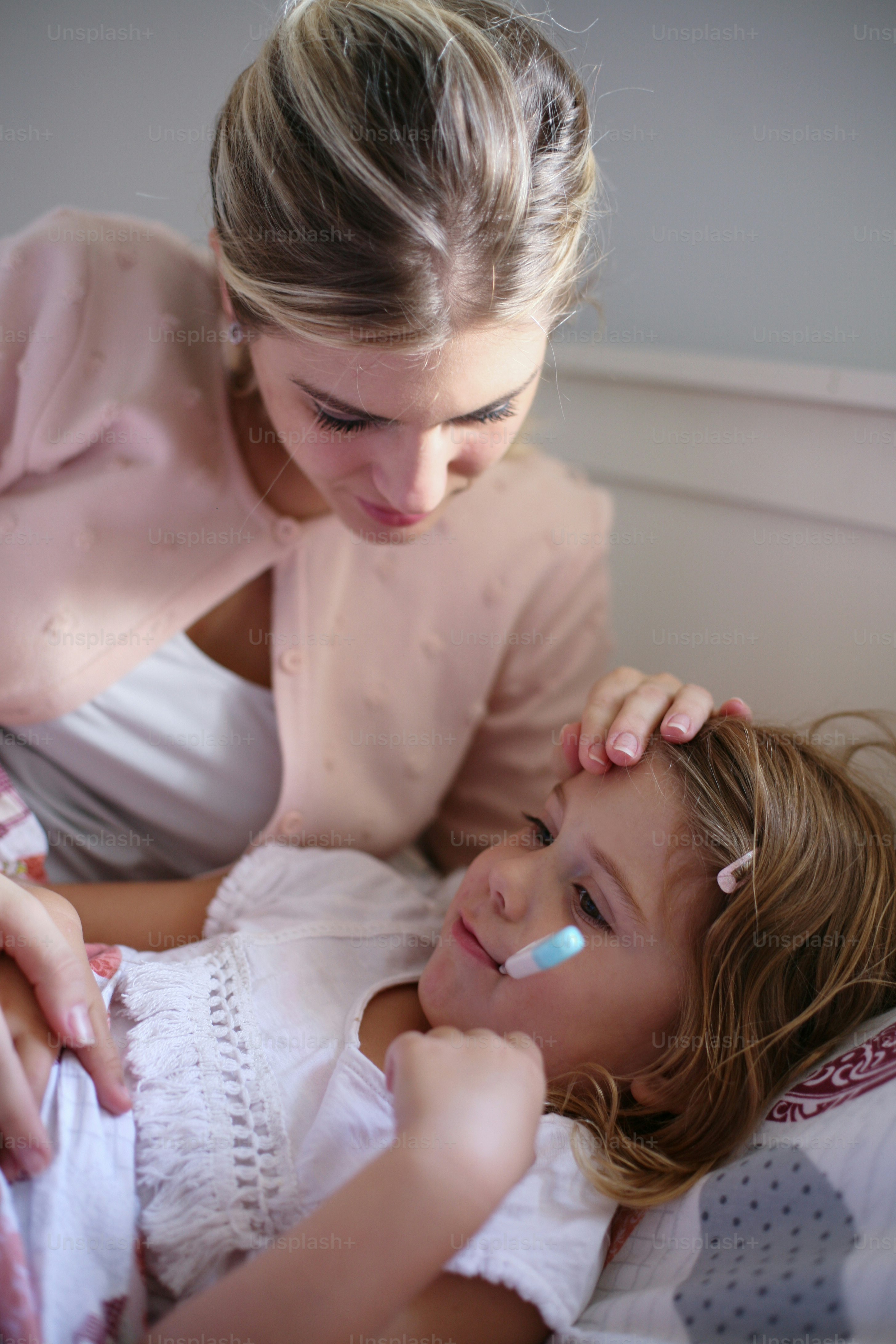 Worried mother measuring temperature her daughter.