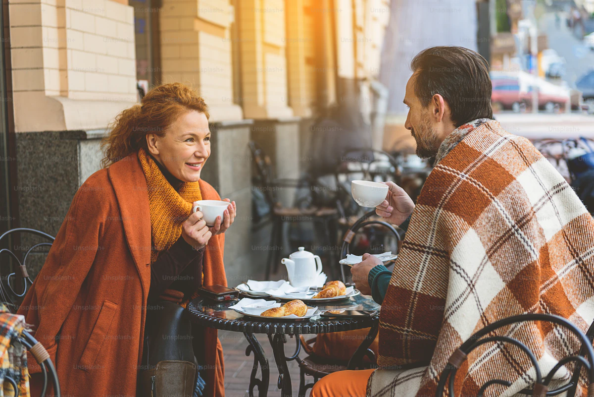 Zwei Erwachsene mittleren Alters unterhalten sich in einem Café