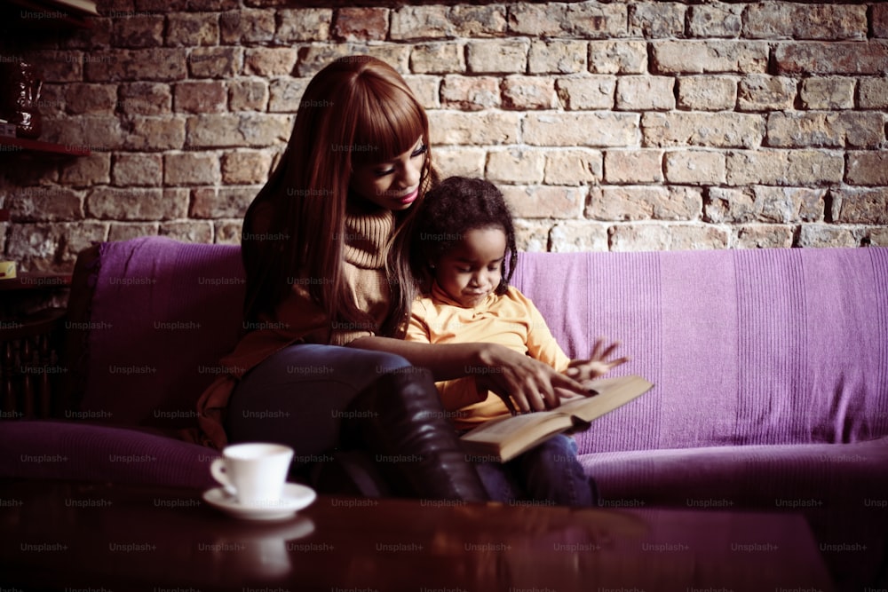 Mother and her daughter reading a book.