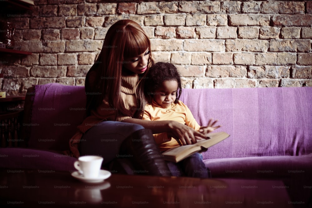 Mother and her daughter reading a book.