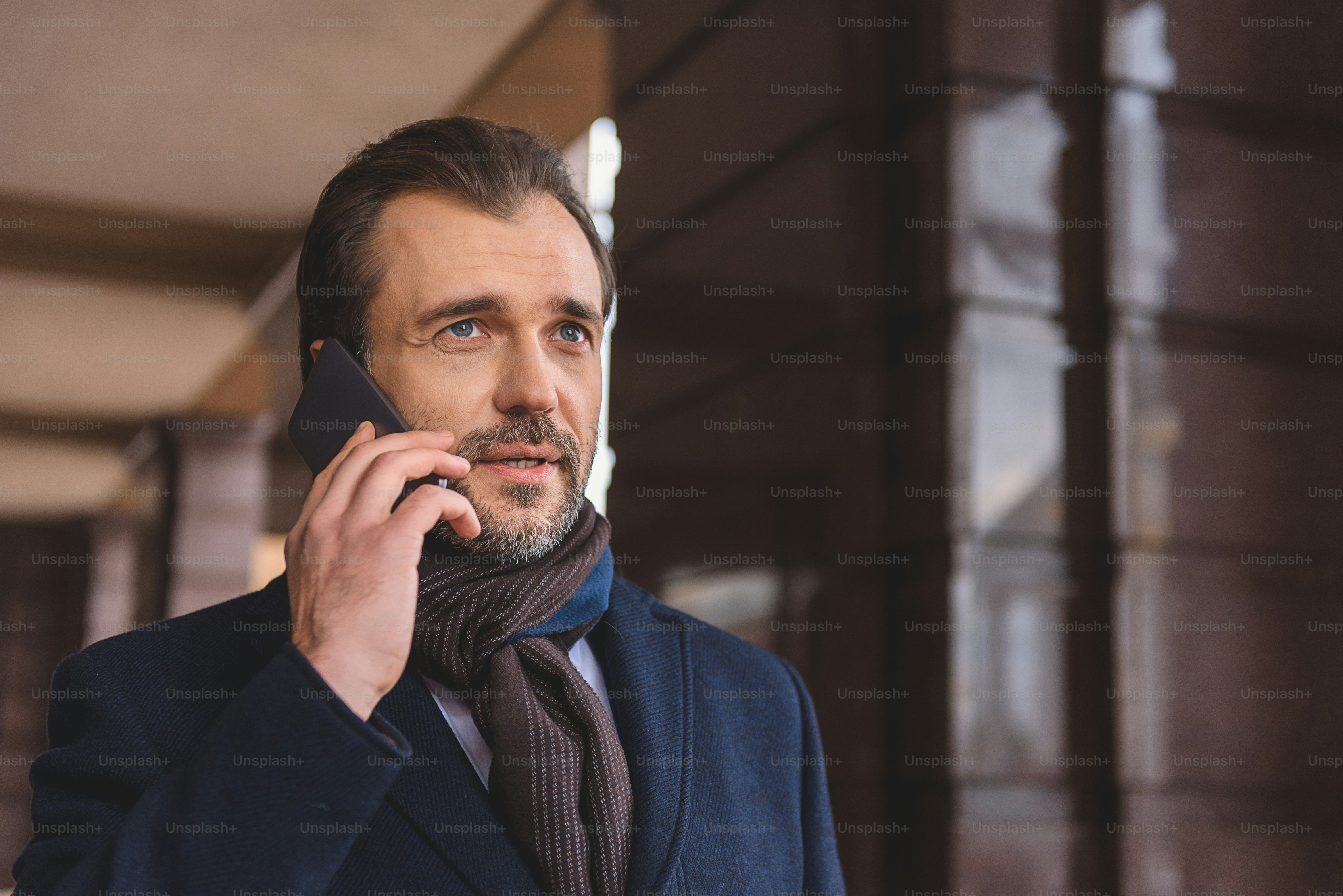 Successful business deal. Man is talking on mobile phone and smiling ...