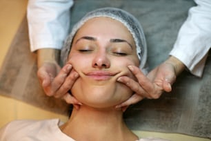 Mulher tendo seu rosto massageado.