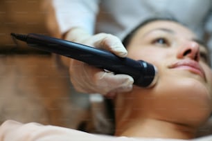 Young woman having ultra sound face. Focus is on hand.