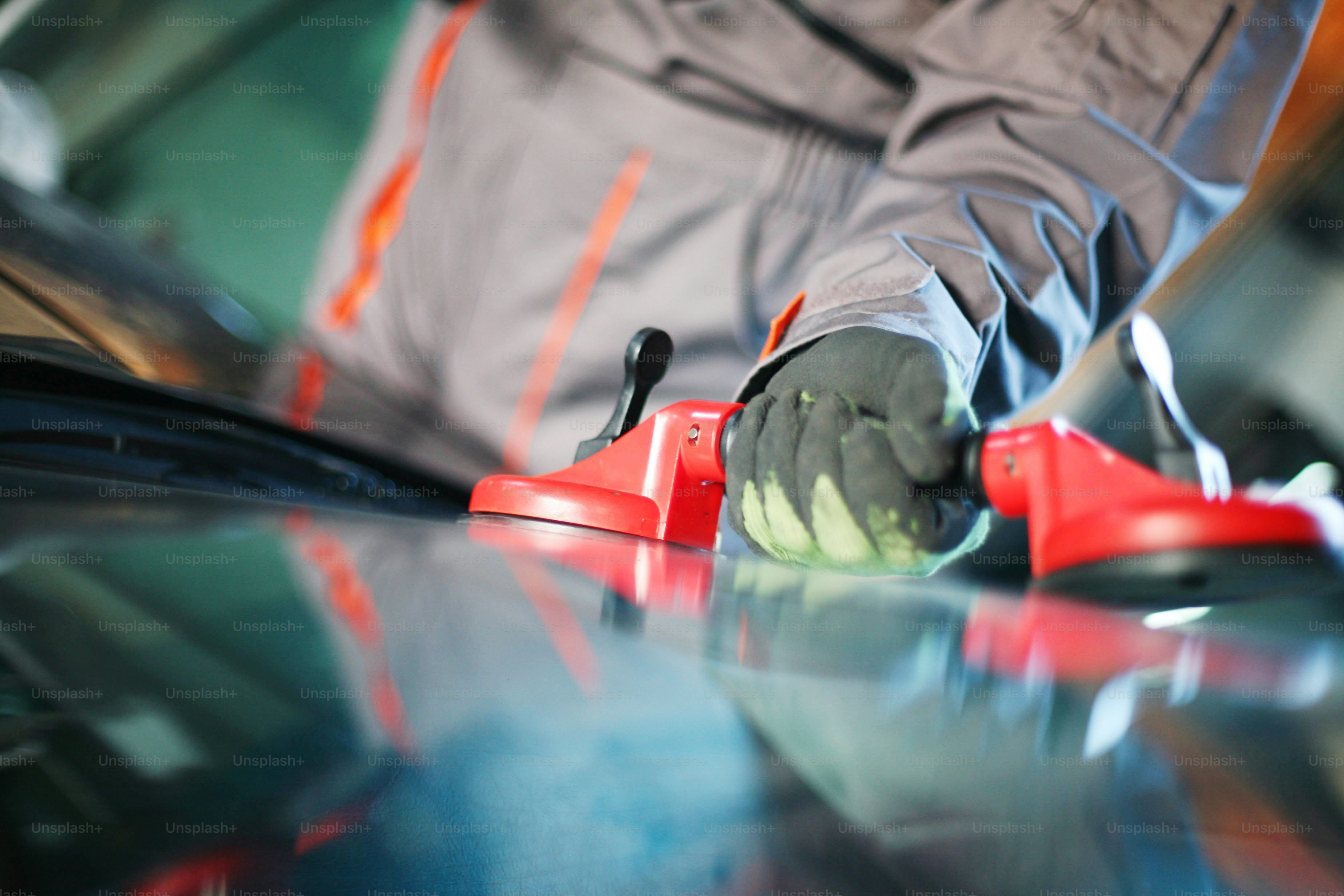 Mechanic changing glass in his workshop.Focus on hand.