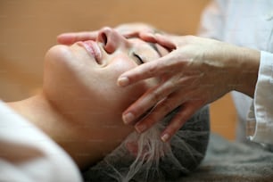 Mulher tendo seu rosto massageado.