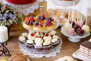 Brauner Holztisch mit verschiedenen Keksen, Torten, Kuchen, Cupcakes und Kuchen. Studioaufnahme.