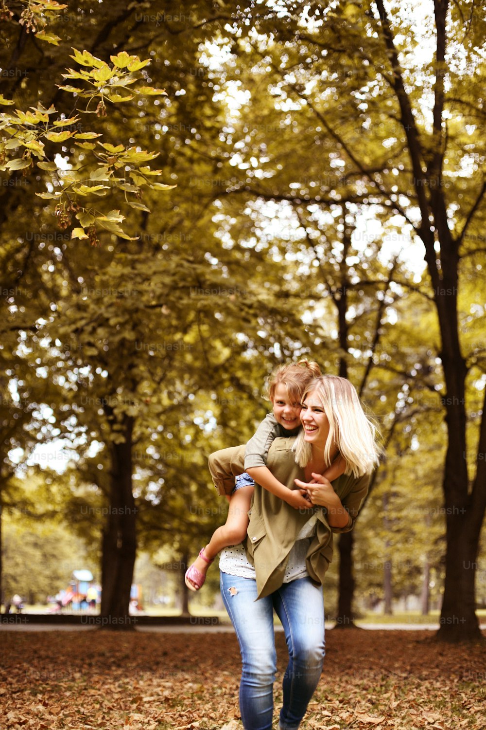 Little girl on a piggy back ride with her mother.