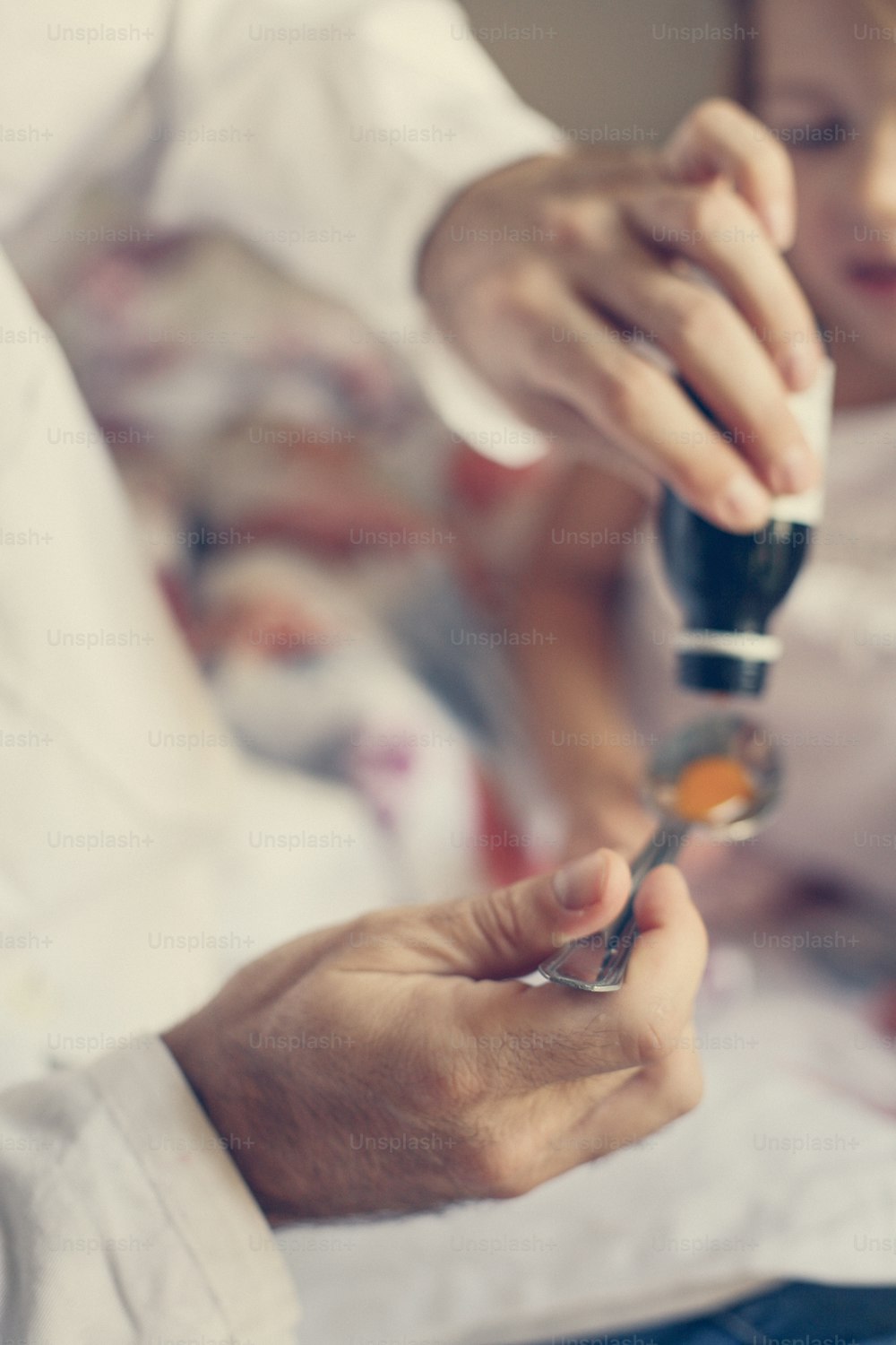 Doctor giving cure to his little patient in the hospital. Close up oh hands.