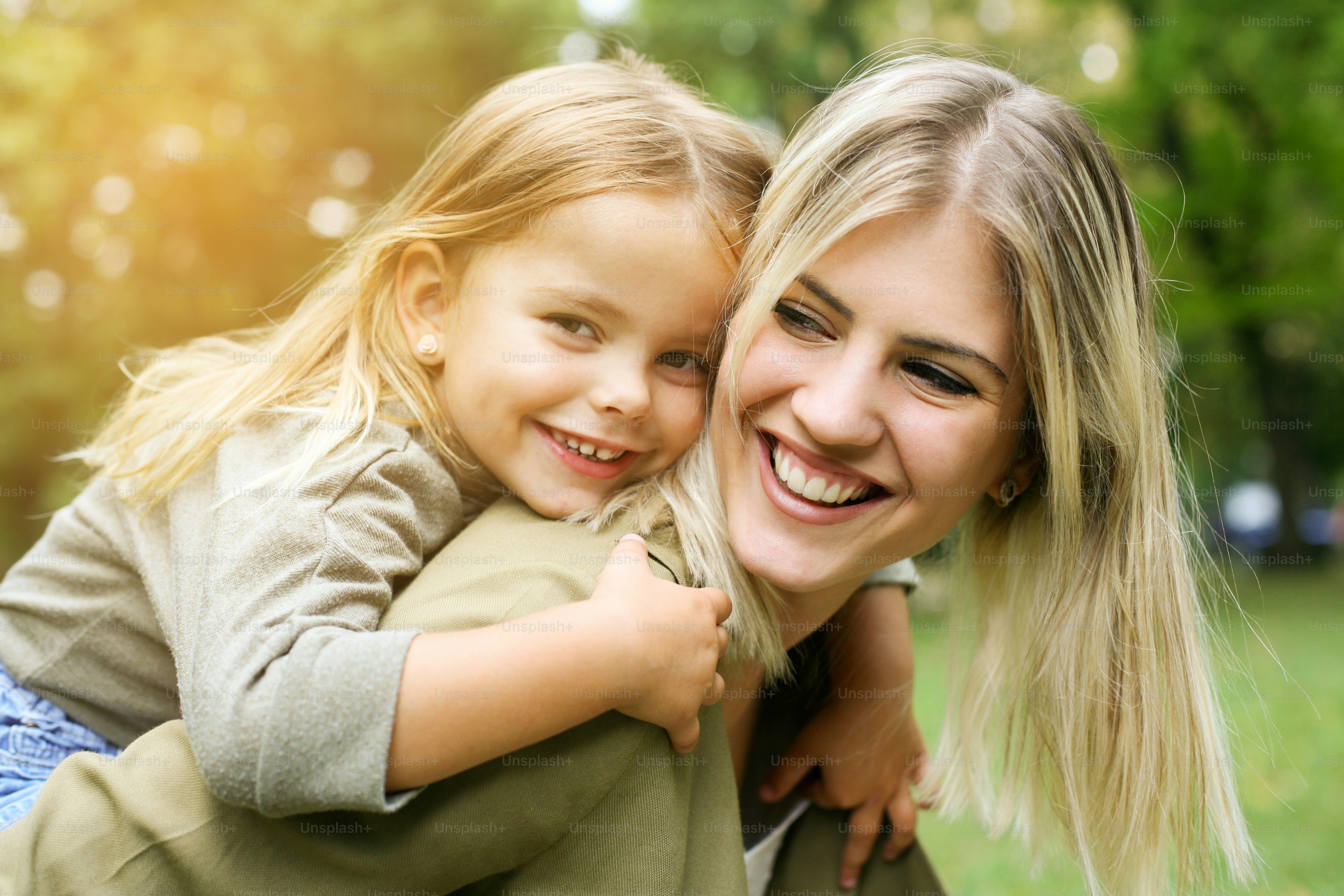 Cute young daughter on a piggy back ride with her mother.
