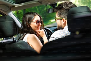 Portrait of young couple driving a car.