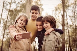 Group of children making self portrait in park.