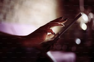 African woman typing on digital tablet. Focus on hands.