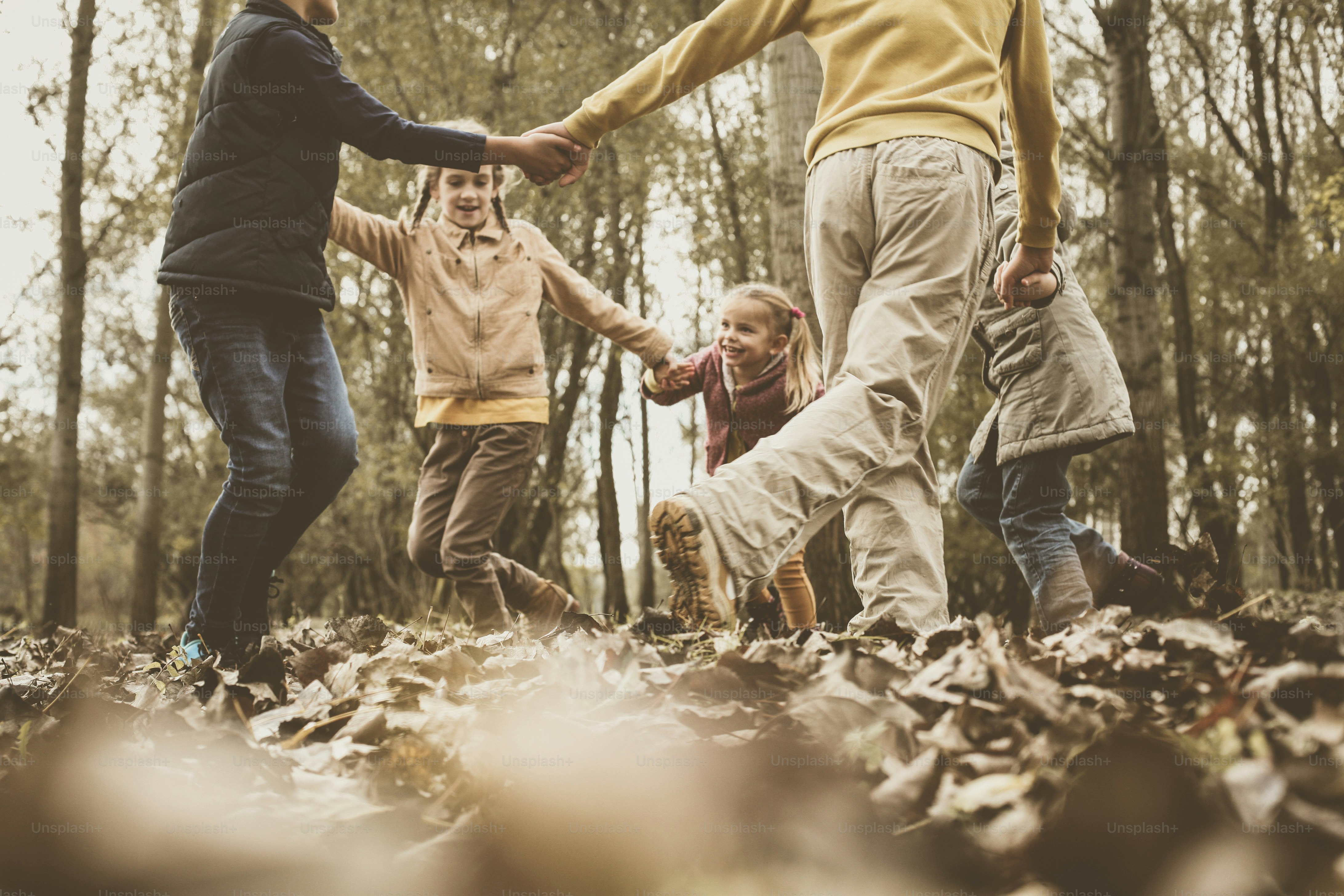 Gruppe von fünf Personen, die Spaß im Herbstpark haben.