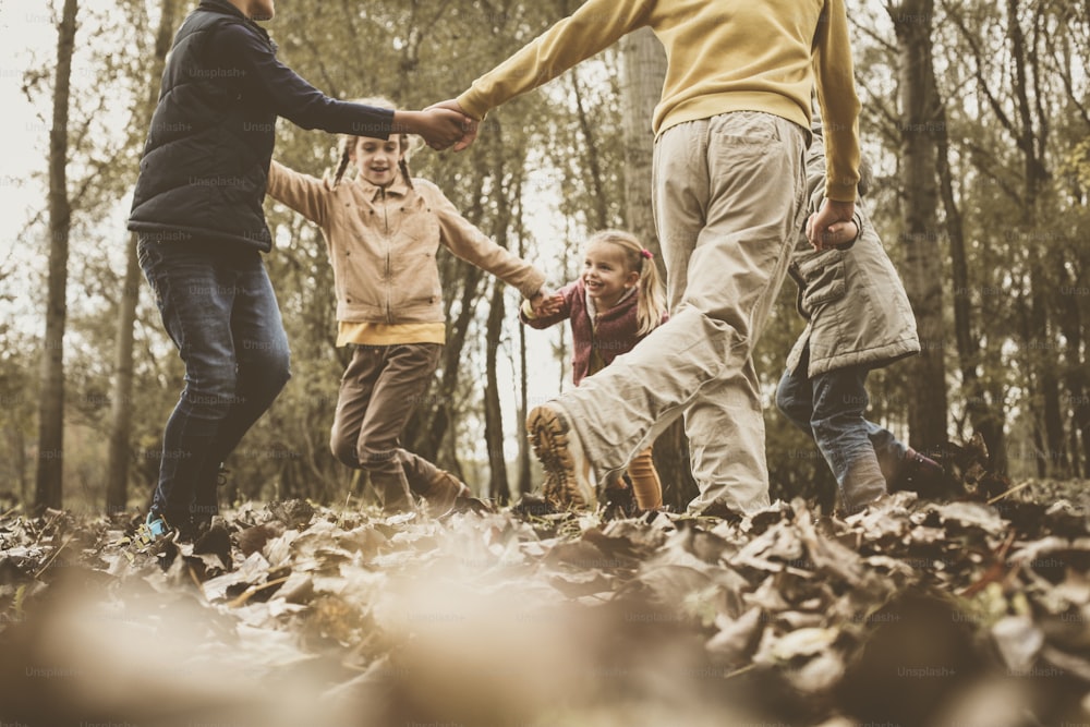 Groupe de cinq personnes s’amusant dans le parc d’automne.