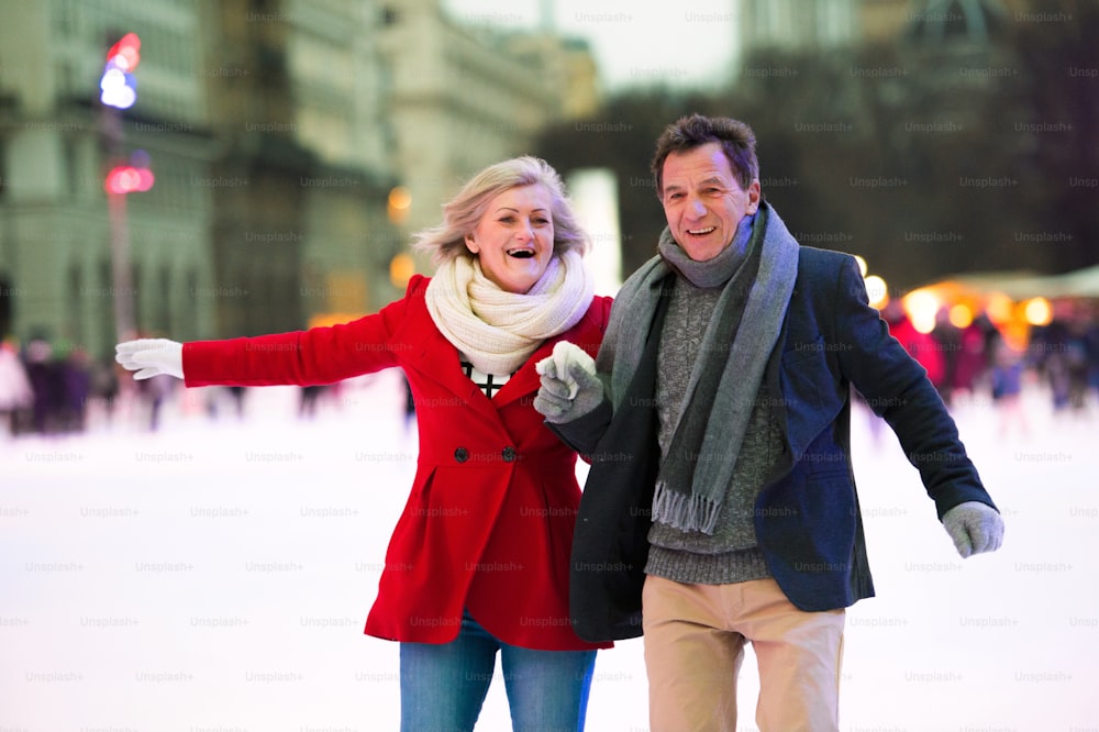 Beautiful senior couple ice skating in historical centre of the city of Vienna, Austria. Winter.