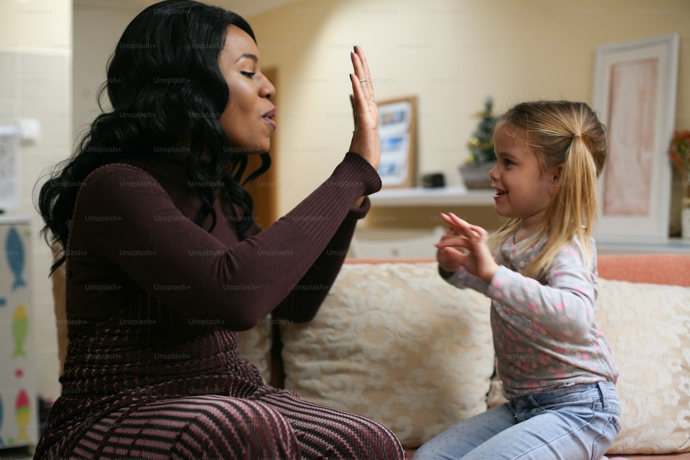 African American woman playing with girl.