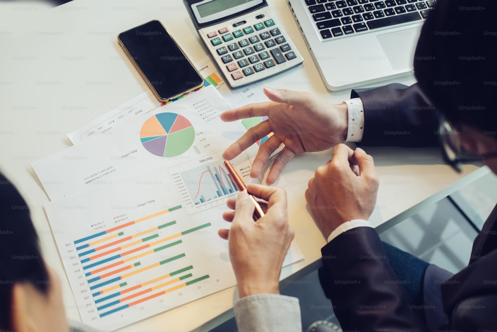 Two businessmen working with documents and discussing marketing plan.