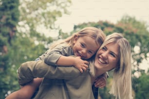 Little girl lying on mother's piggyback .