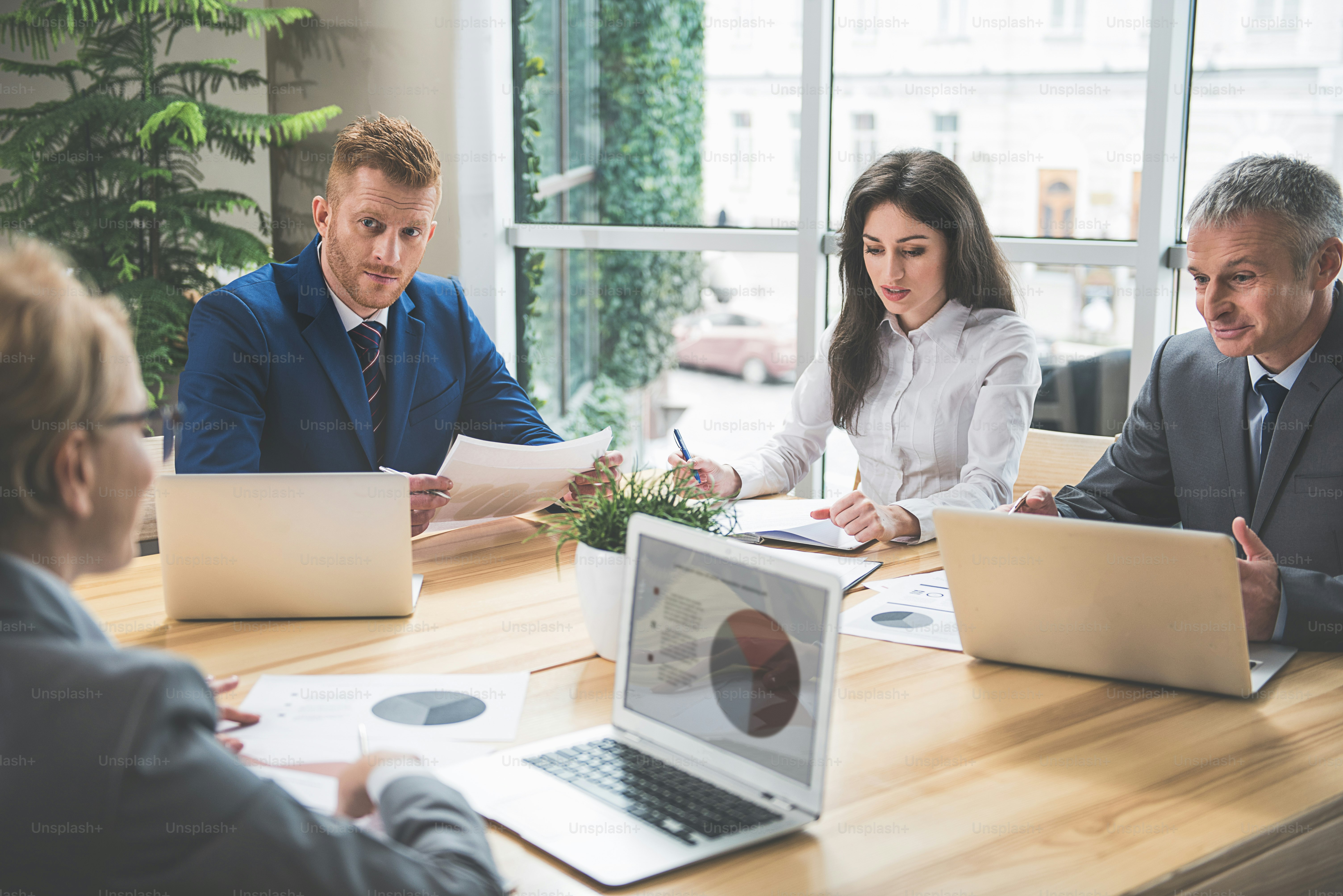 concentrated men and women are having a conference. They are discussing a business plan