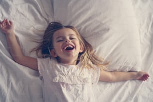Cheerful little girl in bed.