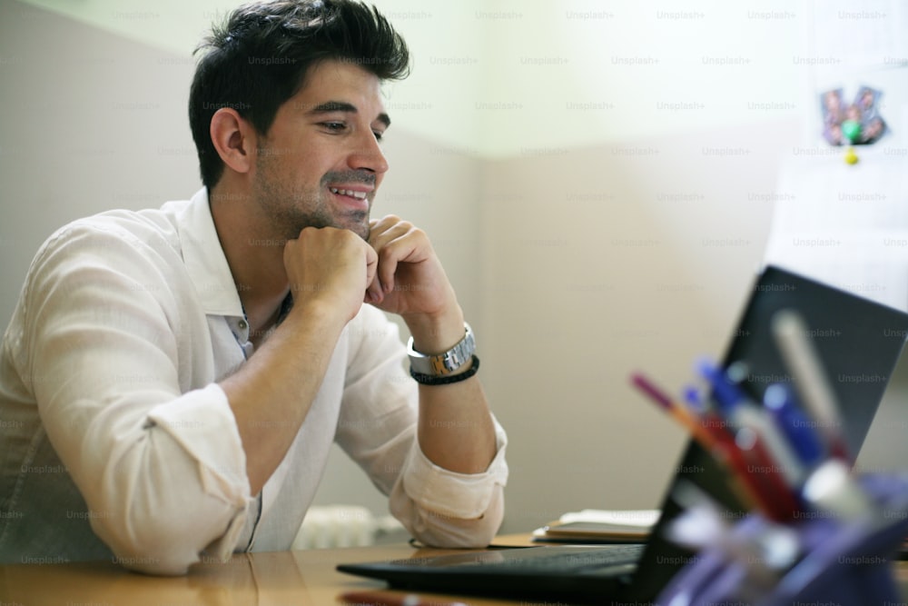 Jeune homme d’affaires travaillant sur un ordinateur portable dans son bureau à domicile.