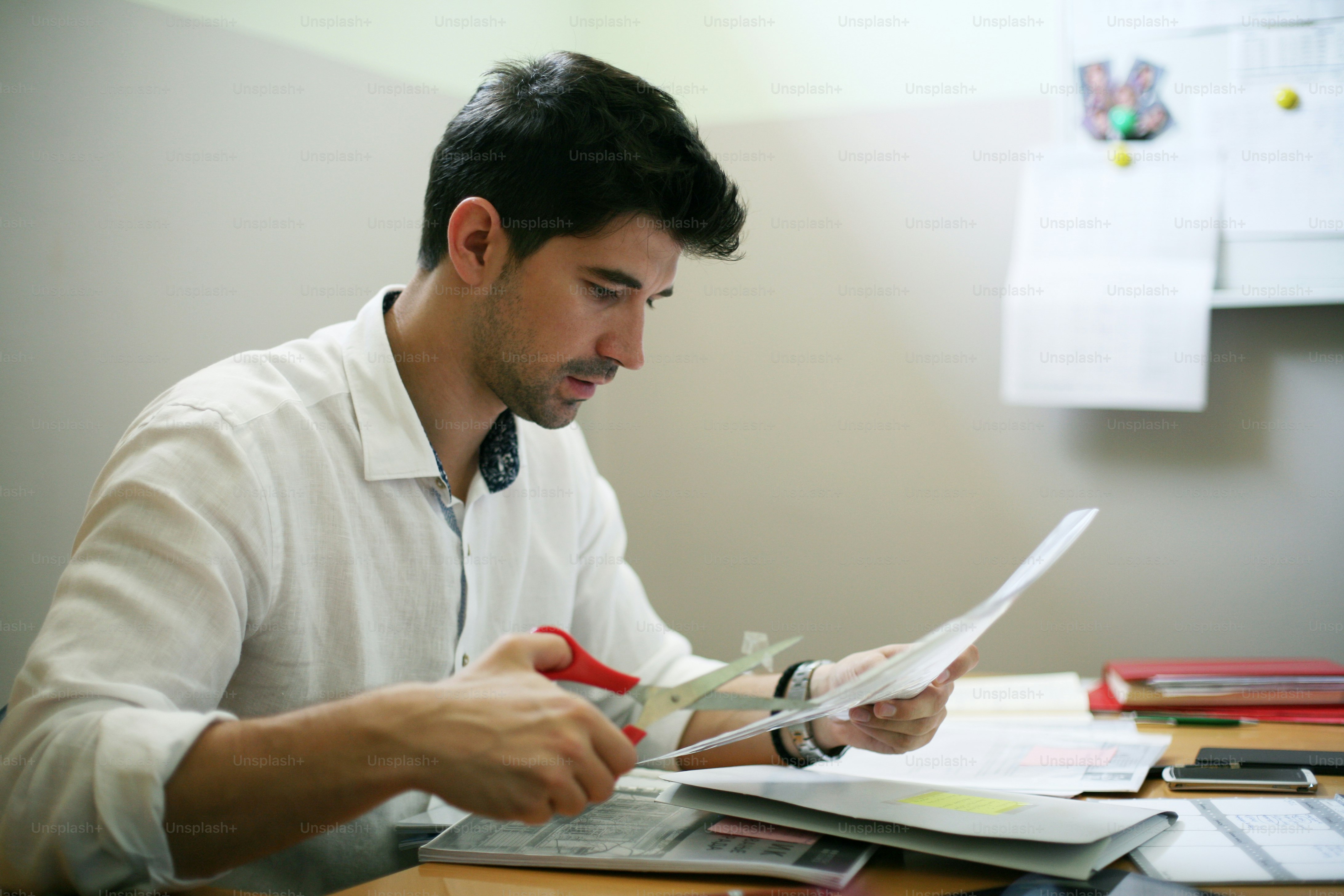Business man cutting paper in office.