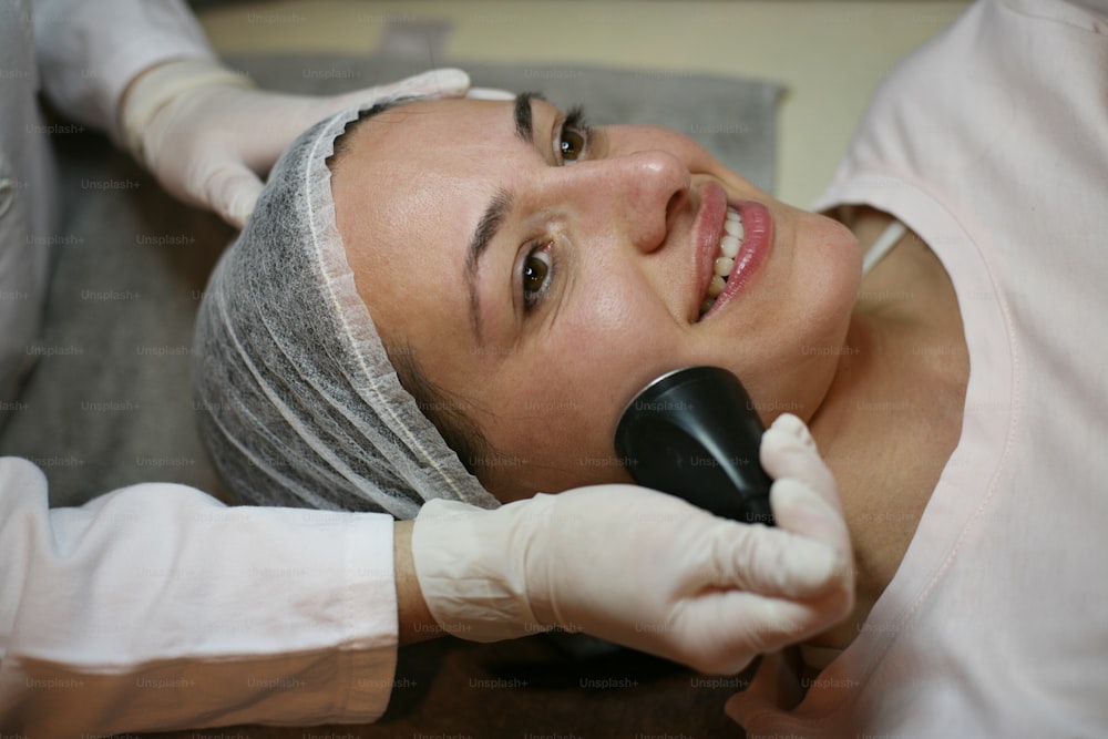 Mujer joven que tiene un masaje electrónico en la cara.
