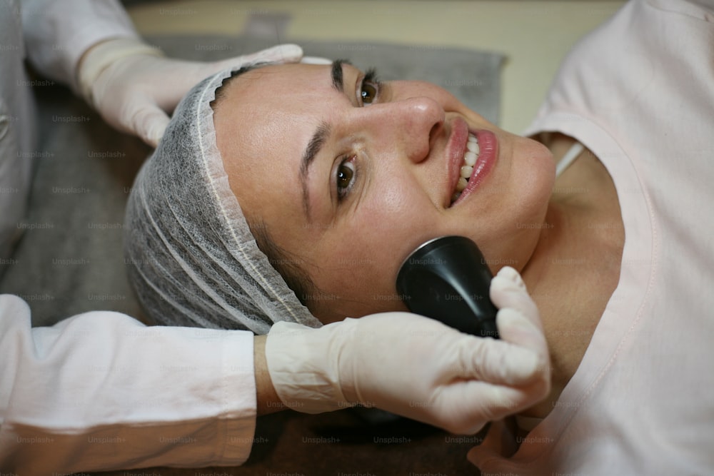 Young woman having electronic massage face.