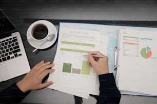 Businessman working at office desk with paperwork and other objects around, top view