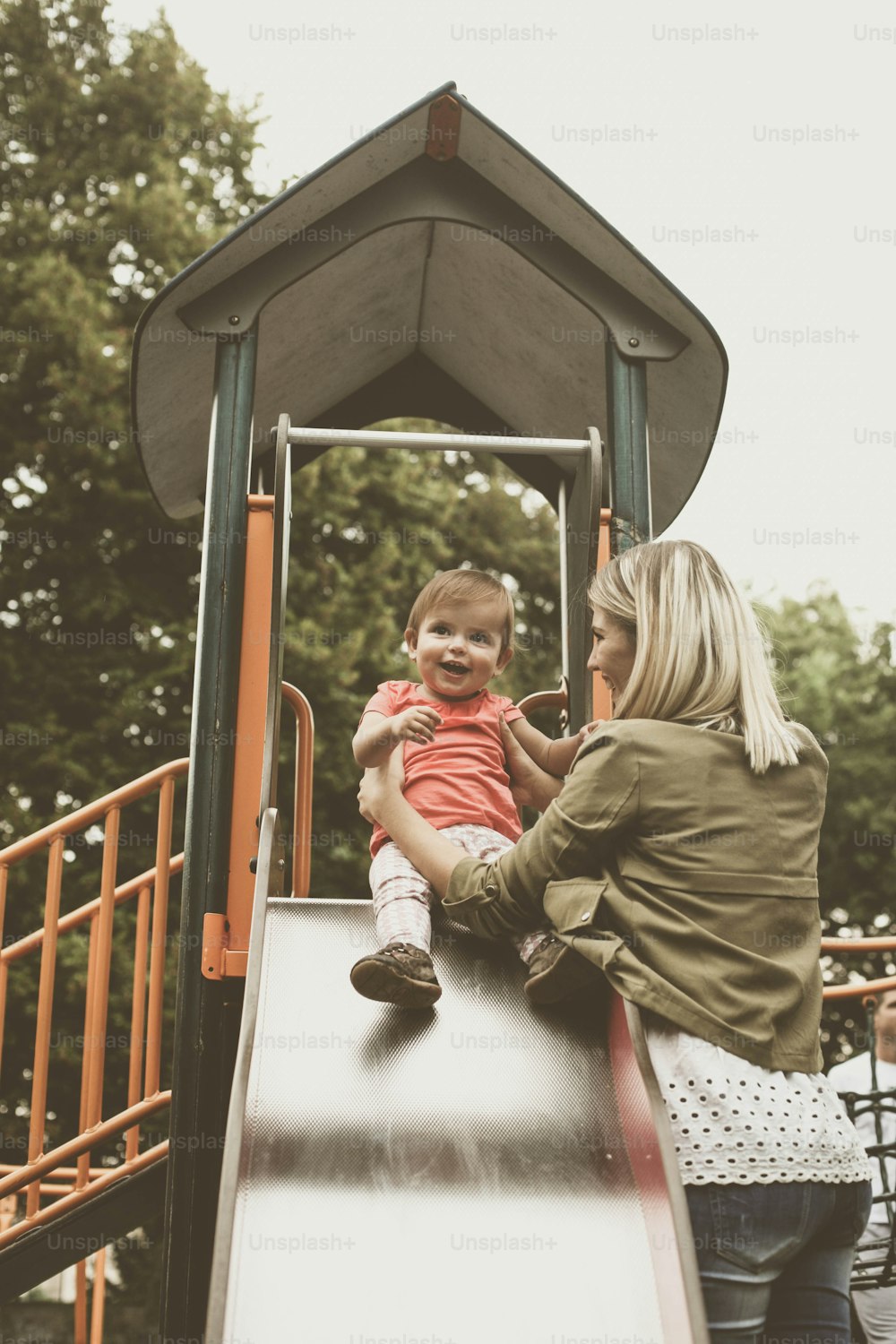 Mother holding a baby on toboggan.