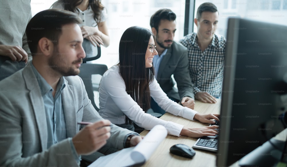 Software engineers developing applications together in office