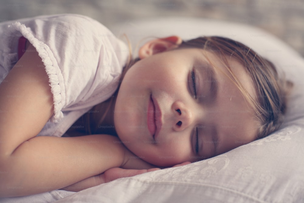 침대에서 자고 있는 어린 소녀.
