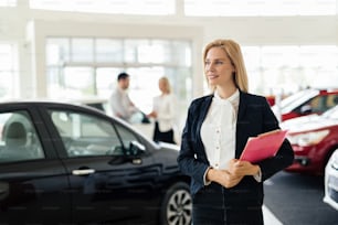 Salesperson selling cars at car dealership