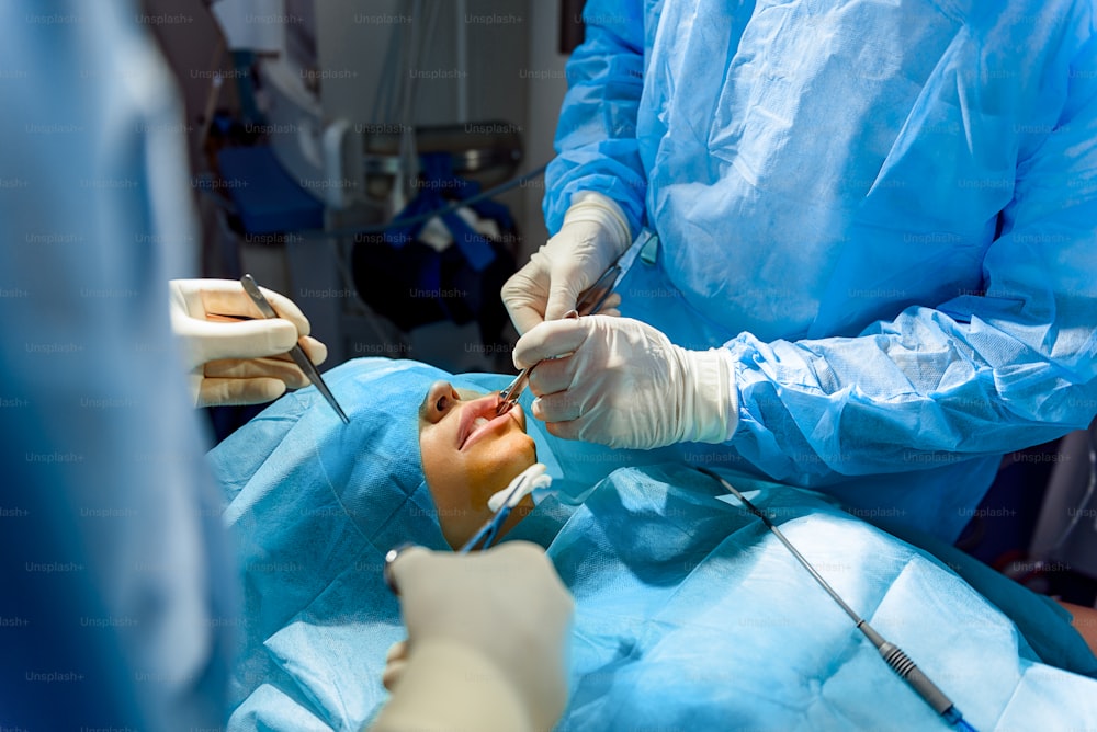 Chirurgen operieren mit speziellen medizinischen Werkzeugen. Sie stehen um den Patienten herum