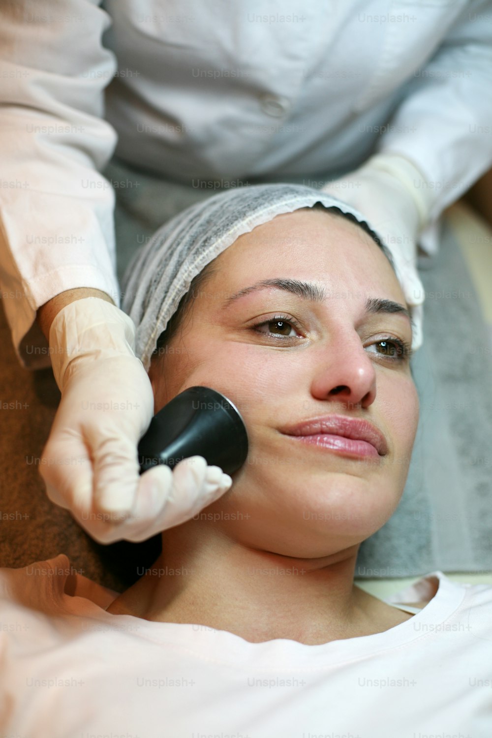 Giovane donna che ha il viso di massaggio elettronico.