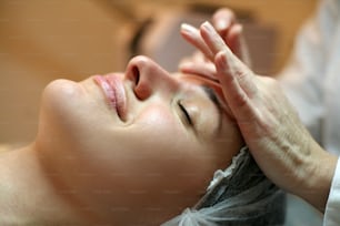 Woman having her face massaged.