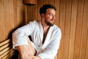 Handsome man relaxing in sauna during wellness weekend