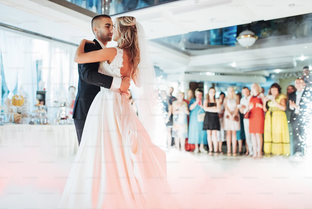 Happy bride and groom and their first dance, wedding in the elegant restaurant with a wonderful light