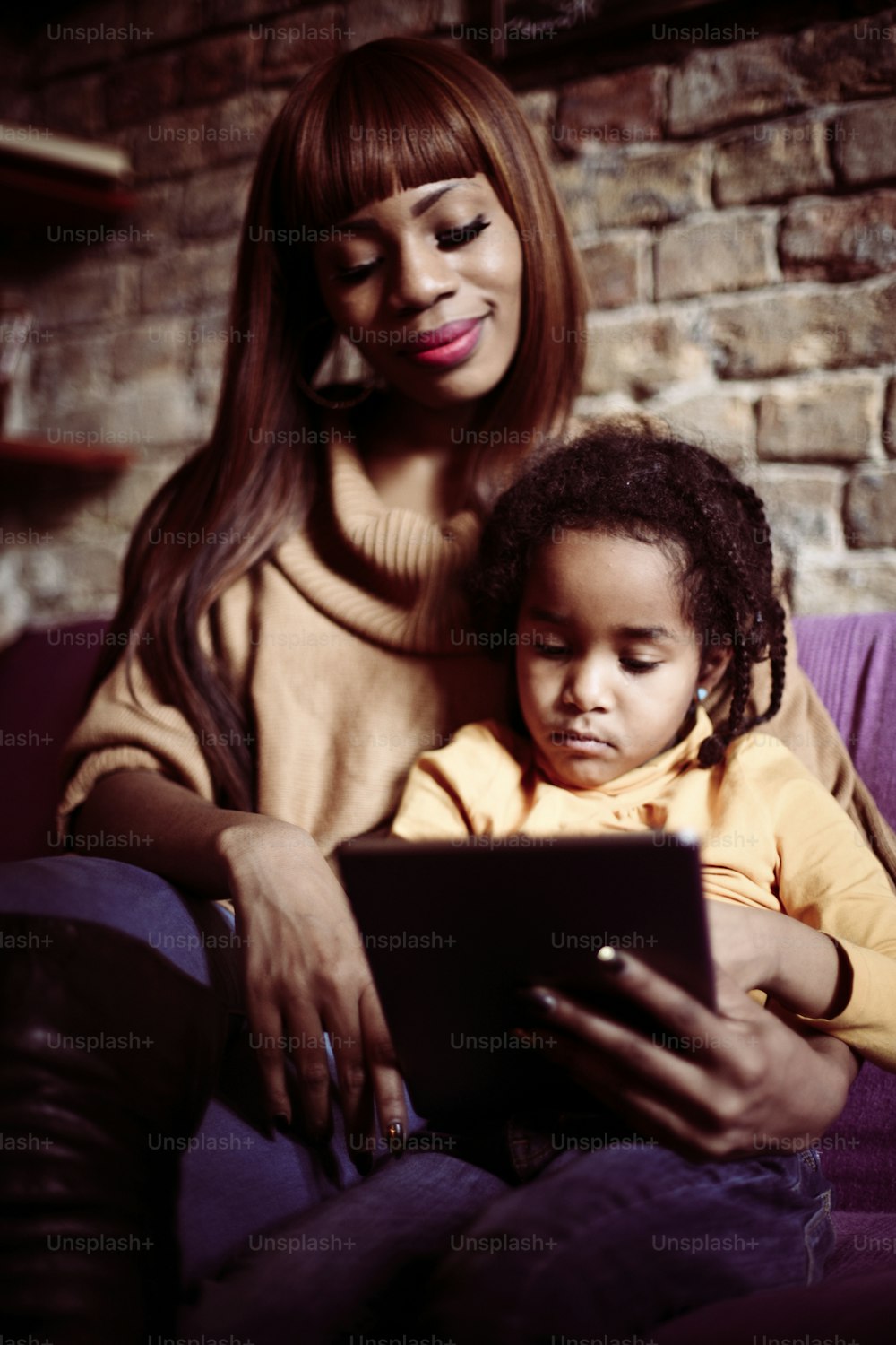 Mother and her daughter using digital tablet.