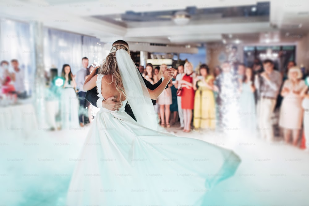 Glückliche Braut und Bräutigam und ihr erster Tanz, Hochzeit im eleganten Restaurant mit herrlichem Licht